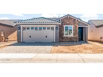 Charming single-story home with a brick and concrete facade, featuring a two-car garage and neat landscaping at 21292 N 270Th Dr, Buckeye, AZ 85396