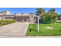 Charming single-story home featuring a well-manicured lawn, mature landscaping, and a two-car garage at 25273 S Berry Brook Dr, Sun Lakes, AZ 85248