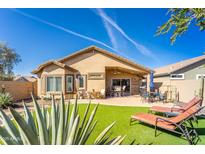 Inviting backyard featuring artificial grass, patio furniture, and a well-maintained landscape, ideal for outdoor relaxation at 31013 N Claridge Cir, San Tan Valley, AZ 85143