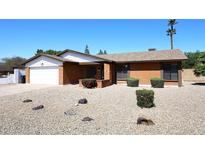 Charming red brick single-story home with desert landscaping and an attached garage at 4902 E Charter Oak Rd, Scottsdale, AZ 85254