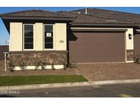 Charming exterior showcasing stone accents, a brown garage door, and a well-manicured lawn at 5633 N 205Th Ln, Buckeye, AZ 85396