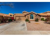 A well-maintained single Gathering house featuring a concrete driveway, stucco siding and mature landscaping at 6520 E Sugarloaf St, Mesa, AZ 85215