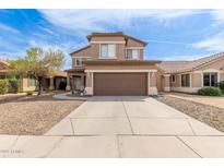 Two-story home with a brown garage door, neutral siding, and a well-maintained front yard at 13001 W Bloomfield Rd, El Mirage, AZ 85335