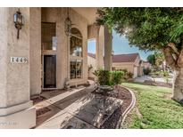 Grand home entrance with tall windows, decorative pillars, and a cozy outdoor seating area at 1449 W Commerce Ave, Gilbert, AZ 85233