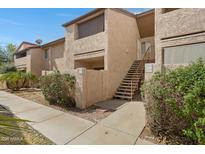 A two-story condo unit shows its exterior stucco walls and front staircase with well-maintained landscaping around the entrance at 1942 S Emerson -- # 127, Mesa, AZ 85210