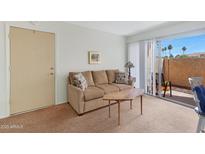 A cozy living room with a sliding glass door provides ample natural light and access to outdoor space at 1942 S Emerson -- # 127, Mesa, AZ 85210