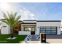 Modern home with drought-resistant landscaping, a sleek front entrance and a contemporary black framed garage at 2642 N Fiesta St, Scottsdale, AZ 85257