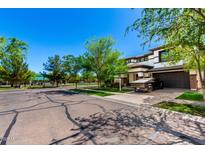 Charming two-story home with a well-maintained lawn, a paved driveway, and mature trees casting shadows on a sunny day at 4167 E Sierra Madre Ave, Gilbert, AZ 85296