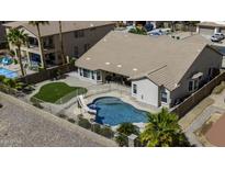 Aerial view of a beautiful private backyard pool with slide, a turf lawn, and a fenced-in area at 43271 W Mcclelland Dr, Maricopa, AZ 85138