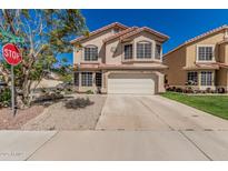Charming two-story home with a tile roof, lush lawn, and an attached two-car garage at 439 N Cobblestone St, Gilbert, AZ 85234