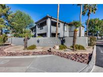 Elegant multi-story condominium featuring well-maintained landscaping with palm trees and a decorative stone perimeter wall at 7401 W Arrowhead Clubhouse Dr # 2007, Glendale, AZ 85308