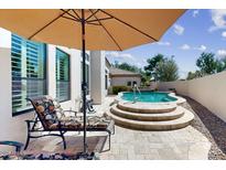 Inviting outdoor patio with comfortable seating under an umbrella, overlooking the pool and yard at 7705 E Doubletree Ranch Rd # 36, Scottsdale, AZ 85258
