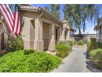 Inviting front exterior showcasing a covered porch, desert landscaping, and a charming American flag at 10132 E Isleta Ave, Mesa, AZ 85209