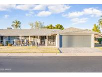 Charming home featuring a low-maintenance front yard, covered porch, and attached garage for convenient parking at 10326 W Kingswood Cir, Sun City, AZ 85351