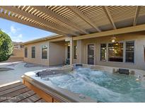 Inviting hot tub with a pergola and fan, perfect for relaxation and outdoor enjoyment at 11413 S Coolwater Dr, Goodyear, AZ 85338
