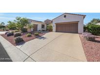 Charming single-story home with desert landscaping, solar panels, a long driveway and a two-car garage at 12950 W Quinto Dr, Sun City West, AZ 85375