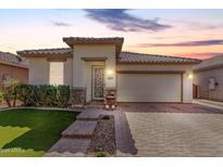 Charming single-story home with neutral stucco, tile roof, brick accents, manicured lawn, and a two-car garage at 22607 W Antelope Trl, Buckeye, AZ 85326