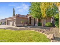 Charming single-story home showcasing desert landscaping, a three-car garage, and a welcoming front entry at 2894 E Melody Ln, Gilbert, AZ 85234