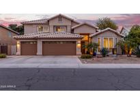 Charming two-story home with a three-car garage, desert landscaping, and warm exterior lighting at dusk at 5342 W Linda Ln, Chandler, AZ 85226