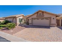 Charming single-story home featuring a private courtyard and brick-paved driveway leading to an attached two-car garage at 14443 W Morning Star Trl, Surprise, AZ 85374