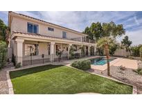 Inviting backyard with green lawn, pool, covered patio, and manicured landscaping at 1614 E Kathleen Rd, Phoenix, AZ 85022