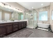 A luxurious bathroom featuring a glass shower, soaking tub, and dual sink vanity at 1620 E Cloud Rd, Phoenix, AZ 85086