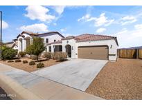 Charming single-story home with a well-maintained front yard, two car garage and terracotta colored roof tiles at 30382 W Vale Dr, Buckeye, AZ 85396