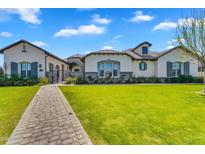 Stunning single Gathering home featuring beautiful landscaping, a paver walkway, and a private gated entrance at 4037 E Minton Cir, Mesa, AZ 85215
