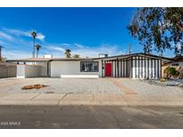 Charming home featuring a red door, black and white accents, and low maintenance landscaping at 5744 W Indian School Rd, Phoenix, AZ 85031