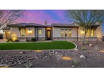 Charming home featuring a manicured front yard, stone accents, and a well-lit exterior enhancing curb appeal at 6328 W Fetlock Trl, Phoenix, AZ 85083