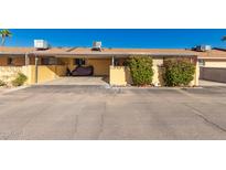 Charming home featuring a covered carport and well-maintained landscaping with decorative shrubs and colorful flower accents at 711 E Laurel Dr # 17, Casa Grande, AZ 85122