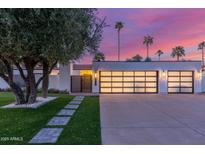 Modern home featuring a well-manicured lawn, sleek garage doors, and a charming walkway at 8618 E Via De Encanto --, Scottsdale, AZ 85258