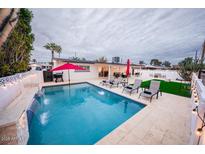 Inviting backyard pool with waterfall feature, lounge chairs, barbecue, and outdoor dining, perfect for relaxing and entertaining at 8725 E Vista Dr, Scottsdale, AZ 85250
