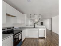 Bright kitchen featuring white cabinetry, stainless steel appliances, and wood-look flooring at 11474 N 79Th Dr, Peoria, AZ 85345