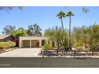 Charming single-story home featuring a carport, desert landscaping, and two majestic palm trees at 1401 E Griswold Rd, Phoenix, AZ 85020