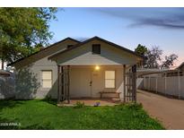 Charming single-story home with a covered front porch, well-maintained lawn, and covered parking at 2032 E Harvard St, Phoenix, AZ 85006