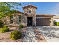 Charming stone facade and well-maintained landscaping enhance curb appeal of this house at 22214 E Cherrywood Dr, Queen Creek, AZ 85142