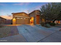 Charming single-Gathering home featuring a stone entrance, two-car garage, and well-manicured landscaping at 24117 N 165Th Dr, Surprise, AZ 85387