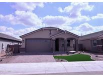 Charming single-story home featuring a brick driveway, two-car garage, and manicured front lawn at 34997 N Sacramento Wash Rd, San Tan Valley, AZ 85144