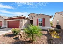 Charming single-story home featuring a two-car garage, desert landscaping, and red window shutters at 41615 W Caliente Dr, Maricopa, AZ 85138