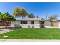 Charming home showcasing a well-manicured lawn, mature trees, and a welcoming facade at 458 N Drew W St # West, Mesa, AZ 85201