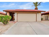 A single car garage with a red tile roof and desert landscaping in front at 5217 E Tunder Cir, Phoenix, AZ 85044