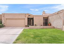 Charming single-story home featuring a manicured lawn, private drive, and desert landscaping at 7937 E Solano Dr, Scottsdale, AZ 85250