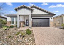 Charming single-story home with well-kept desert landscaping and a brick-paved driveway at 8857 S 167Th Ln, Goodyear, AZ 85338