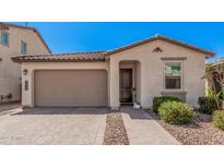 Charming single-story home featuring a two-car garage, paver driveway, and manicured landscaping at 12125 W Levi Dr, Avondale, AZ 85323