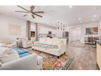 Open-concept living room with hardwood floors, light-colored sofas, and ample natural light at 12125 W Levi Dr, Avondale, AZ 85323