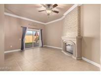 Living room features a ceiling fan, decorative fireplace, and a sliding glass door with access to the backyard at 13628 N 109Th Ave, Sun City, AZ 85351
