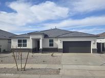 Charming single-story home with a well-maintained front yard and a two-car garage at 15378 W Cottontail Ln, Surprise, AZ 85387