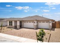 Charming single-story home featuring a three-car garage, neutral colors and brick accents at 16749 W Whispering Wind Dr, Surprise, AZ 85387