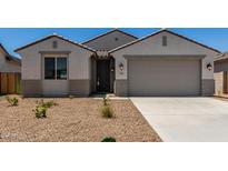Charming single-story home featuring a neutral color scheme, desert landscaping, and an attached two-car garage at 18363 W Monte Lindo Ln, Surprise, AZ 85387